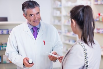 Customer handing a prescription to a pharmacist