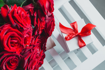 Gift box and red roses. Present on Valentine's Day for woman