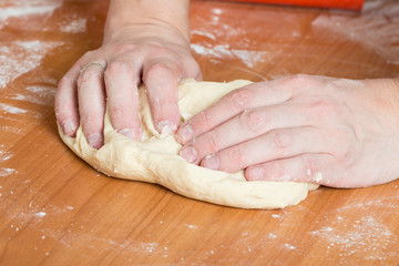 male hands kneading dough on table