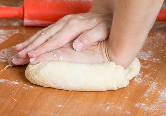 male hands kneading dough on table