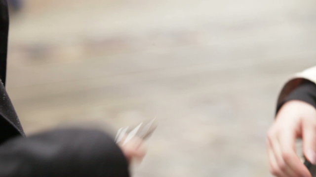 young man and woman give the phone to each other in turn on city