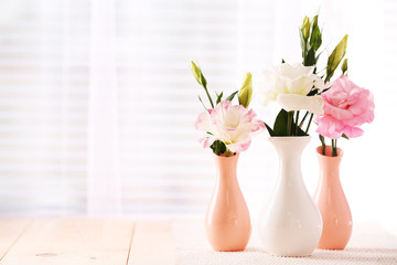 Beautiful flowers in vases with light from window