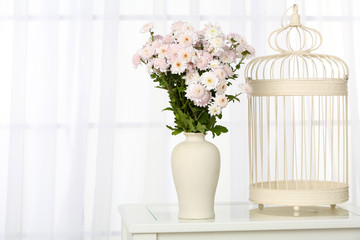 Beautiful bouquet of flowers in vase on window background