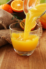 Pouring orange juice from glass carafe,