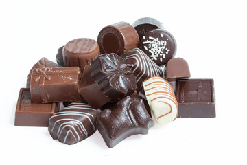 Différents  bonbons en chocolat en vrac sur fond blanc