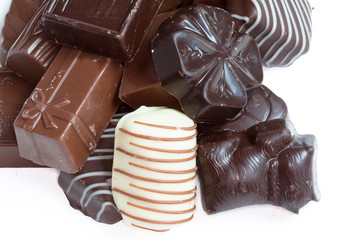 Différents  bonbons en chocolat en vrac sur fond blanc