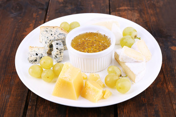Different sort of cheese with grape and saucer