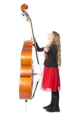 young blond girl looks up to double bass in studio