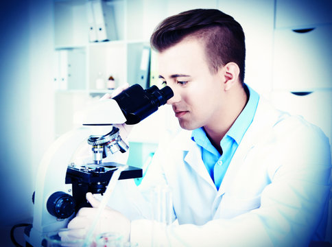 Young male researcher carrying out scientific research in lab