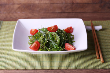 Seaweed salad with slices of cherry tomato