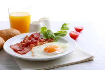 Bacon and eggs on color wooden table and white background