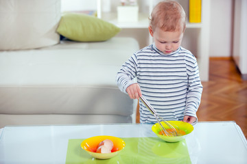 Little boy preparing scrambled eggs