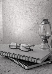 Still life with book Kerosene lamp and glasses