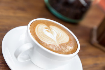 Latte art, coffee on the wooden desk as background