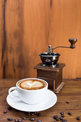 cup of warm coffee and coffee grinder