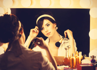 Portrait of a beautiful woman near a mirror