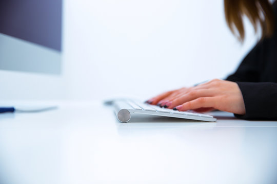 Closeup image of female hands typing on computer keyboard