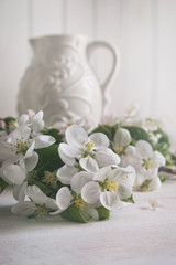 Naklejka na ściany i meble Apple blossom flowers with jug in background