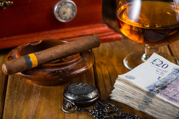 Wealthy man desk, cuban cigars sterling notes, vintage watch and