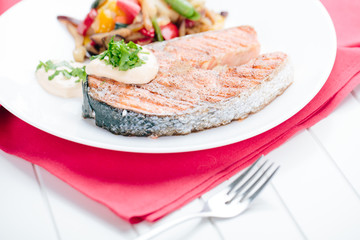 Grilled Salmon with Fresh vegetables on red background
