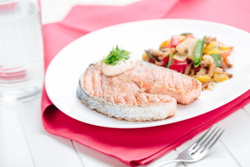 Grilled Salmon with Fresh vegetables on red background
