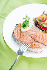 Grilled Salmon with Fresh vegetables on green background