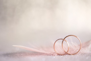 Two Golden Wedding Rings and  Feather - gentle background - 76438699