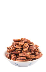 Pecan nut in a white bowl over white background