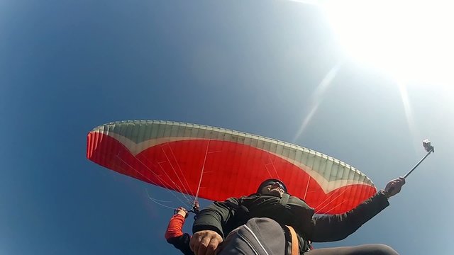 Paragliding against blue sky, extreme sport