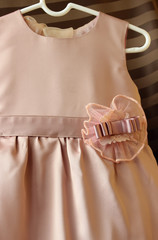 Elegant baby dress on a hanger.