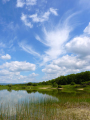 Day landscape with different clouds in the blue sky