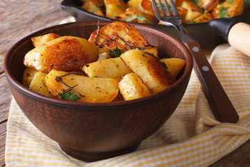 Baked potatoes in a bowl close-up on the table. horizontal
