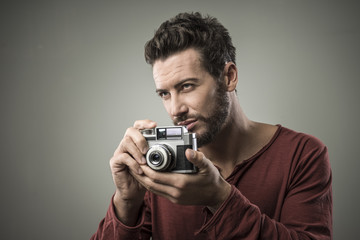 Confident man holding a vintage camera