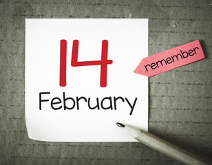 Note with 14 february and pencil on grunge background