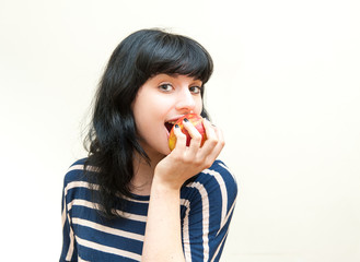 Pretty brunette girl biting red apple