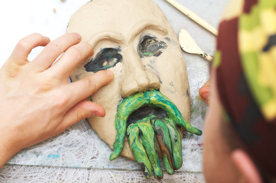 Man sculpting plasticine form of face