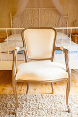 Interior of bedroom. Canopy bed and retro chair. © Voyagerix