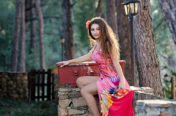 Lovely lady wearing elegant long dress standing among the trees