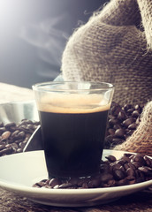 Espresso coffee in glass cup with coffee beans.