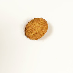 A single biscuit dropped into milk causing a splash.