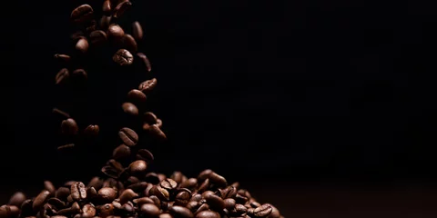 Tuinposter High contrast image of coffee beans being dropped onto pile with © robdthepastrychef