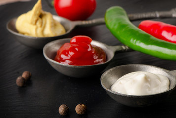 Mustard, tomato sauce and mayonnaise on    table.