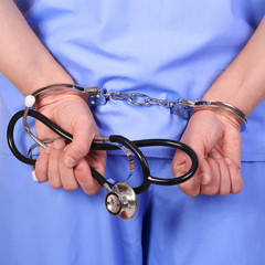 Doctor with stethoscope in handcuffs - 76462675