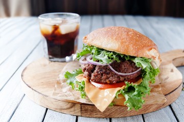 Rustic burgers with a cold drink on wooden