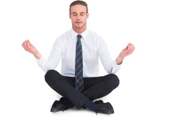 Businessman meditating in lotus pose