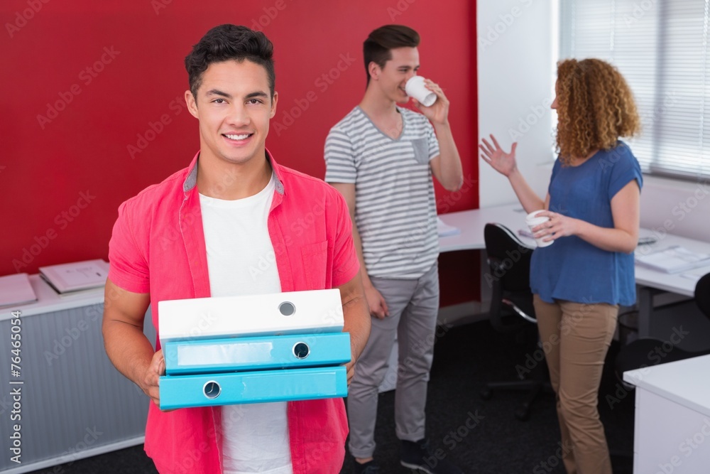 Wall mural Student holding pile of ring binder near classmates with coffee