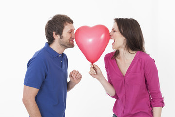 Fototapeta na wymiar Paar mit herzförmigen Ballon, lächelnd