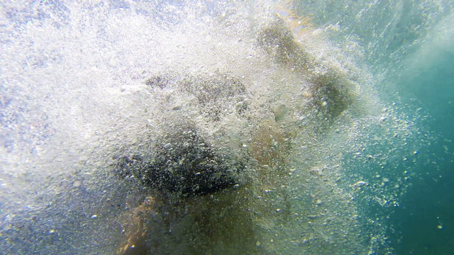 Young man snorkeling with sunrays view from below