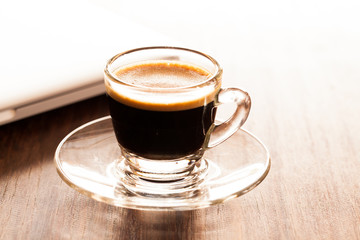 cup of espresso on a wooden background table.