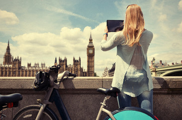 Girl with a tablet against UK Parliament